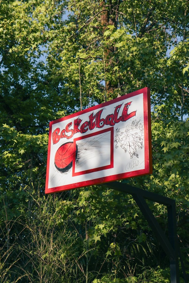 a red and white sign hanging from the side of a tree